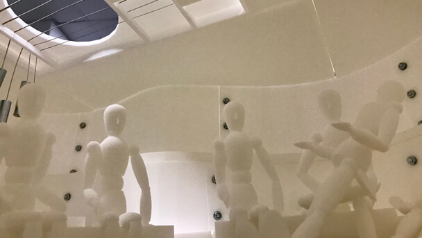White wooden figures sitting inside a guitar instrument